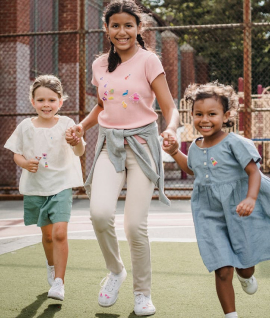 Três crianças correndo de mãos dadas