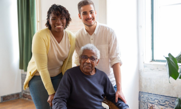 Duas pessoas cuidando de um idoso